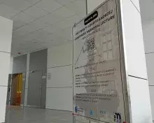 plakat konferencyjny na tle auli wykładowej