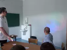 uczestnik wytwarza cień dłoni na tle kolorowych świateł