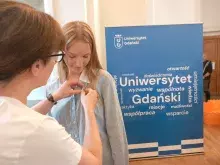 prof. Wolnik podarowuje przypinkę uczennicy