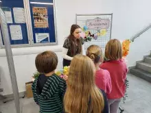 dzieci i studentka przy stoisku kwiaciarni