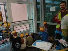 dzieci i student przy stoisku budowlanym