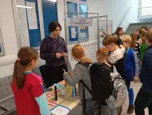 dzieci i student przy stoisku informatycznym