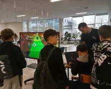 stoisko KN Work In Progress i uczniowie tworzący cyfrowe bombki